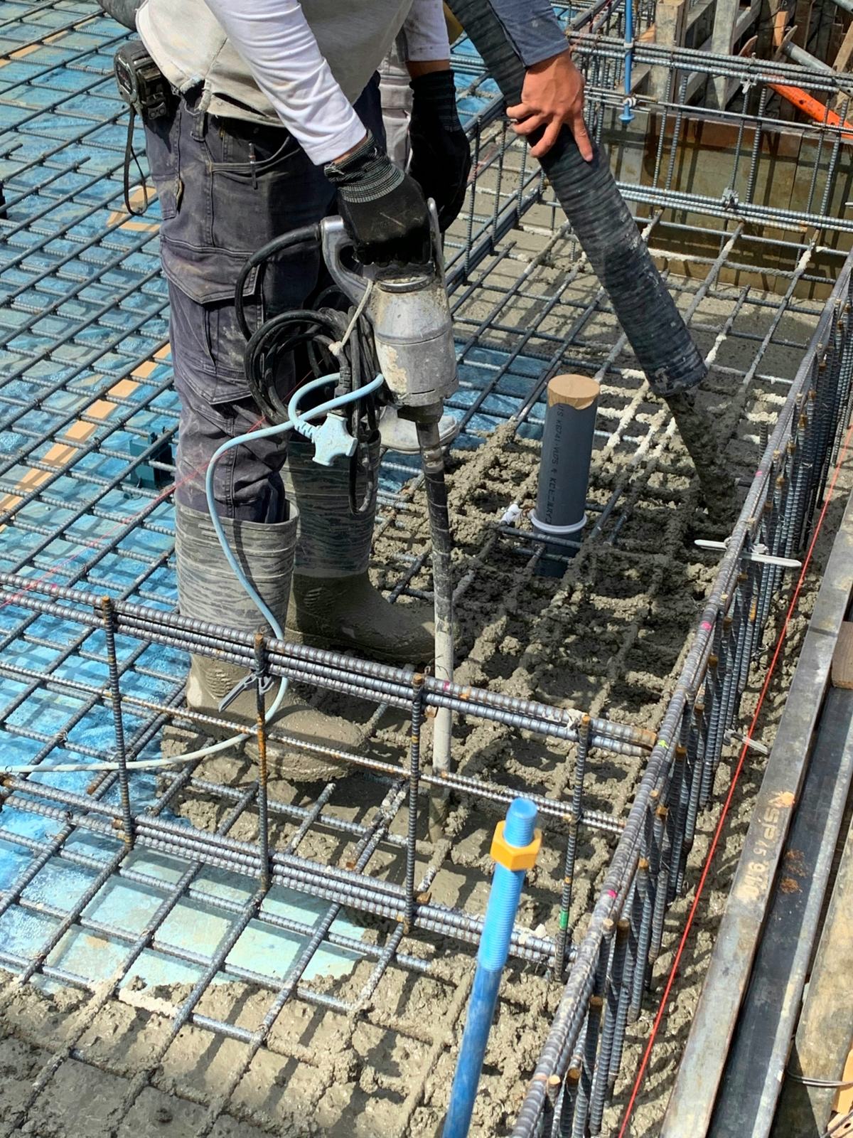 棒形振動機でコンクリートを締め固める作業